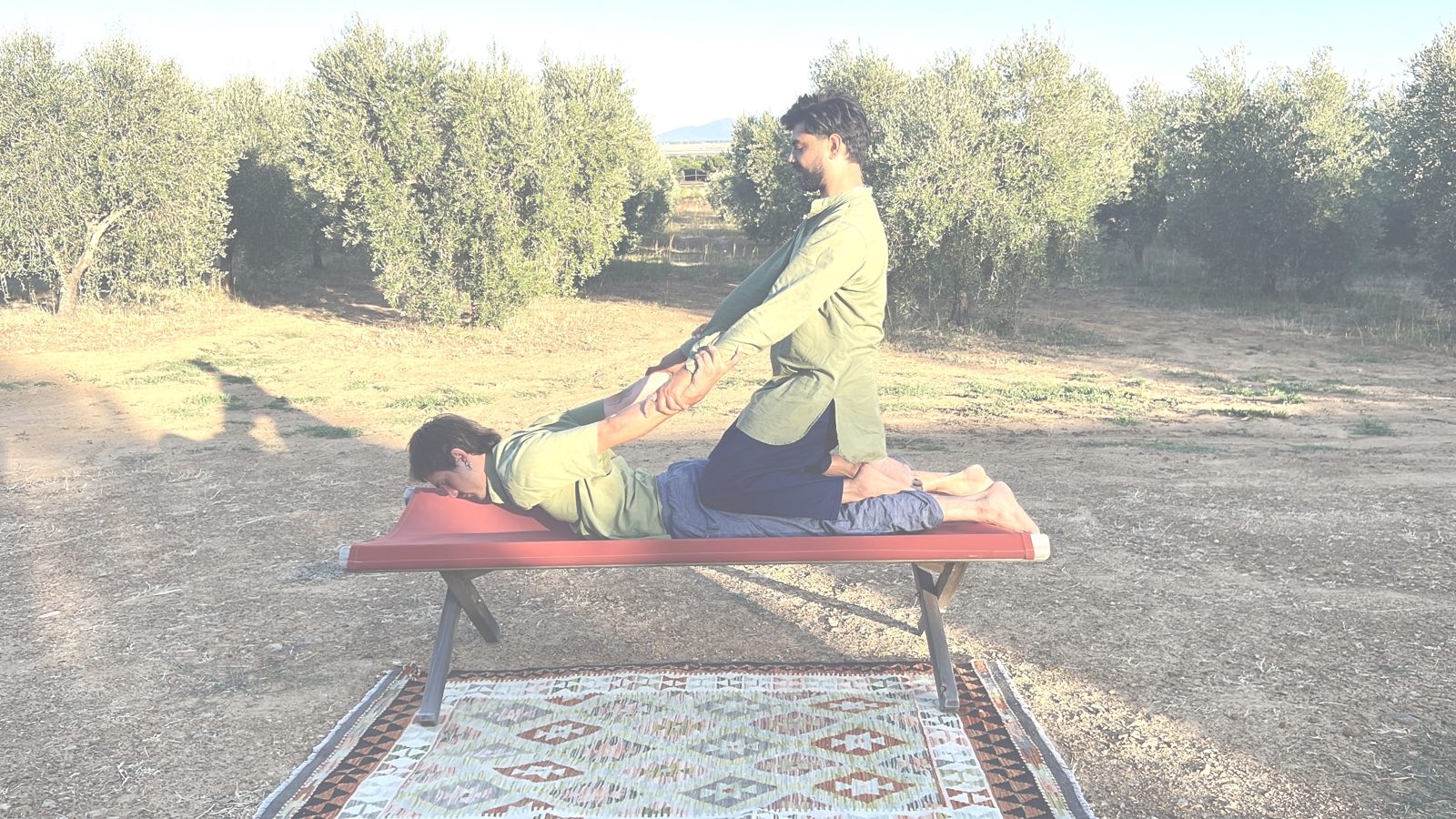 Thai back stretch outdoors in an olive grove